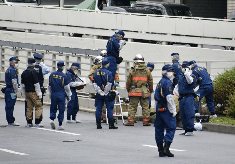 &copy; Reuters. Agentes de policía y bomberos investigan en el lugar donde un hombre que protestaba por un funeral de Estado para el ex primer ministro japonés Shinzo Abe se prendió fuego, cerca de la residencia oficial del primer ministro Fumio Kishida en Tokio, Jap
