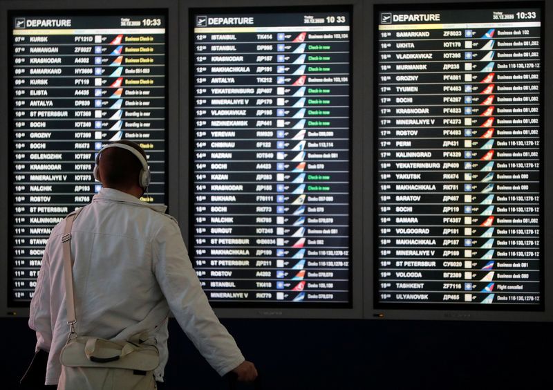 &copy; Reuters. FOTO DE ARCHIVO: Un hombre mira un tablero de información de vuelos en la zona de salidas del Aeropuerto Internacional de Vnukovo en Moscú, Rusia 30 de diciembre de 2020. REUTERS/Evgenia Novozhenina