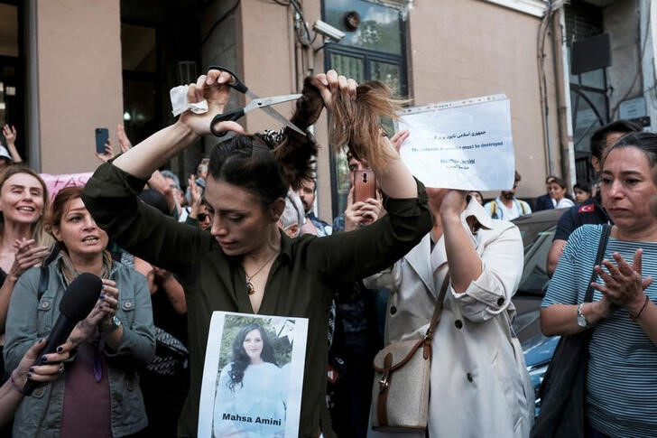 &copy; Reuters. Foto del miércoles de la iraní Nasibe Samsaei, que vive en Turquía, cortándose el cabello en una protesta por la muerte de Mahsa Amini fuera del consulado iraní en Estambul 
Sep 21, 2022. REUTERS/Murad Sezer