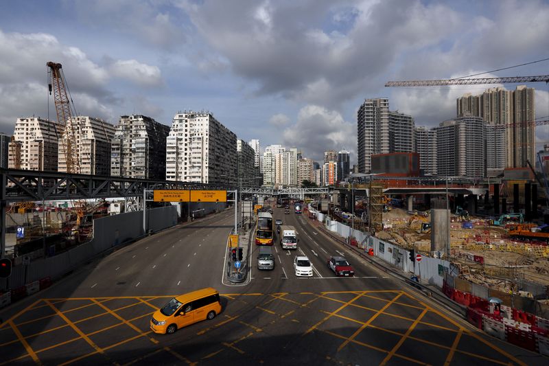 © Reuters. FILE PHOTO: Cars travel down a road between blocks of 45-year-old residential flats (L) and the latest luxury homes (R) near the construction site for a high-speed railway, in West Kowloon, Hong Kong, China July 2, 2015. REUTERS/Bobby Yip/File Photo