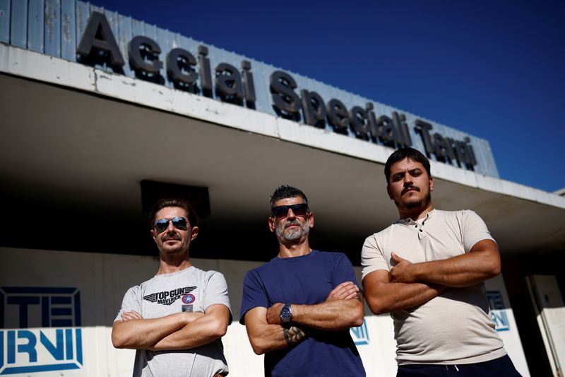 © Reuters. Workers Igor Moresi, Marco Piantoni and Jacopo Calabresi pose for a photo outside the 'Acciai Speciali Terni' steel mill which has been crippled by soaring gas and electricity costs as inflation, looming recession and impossibly high energy bills are set to be on top of the next government's agenda whoever wins the Sept. 25 elections in Terni, Italy, September 20, 2022. REUTERS/Guglielmo Mangiapane