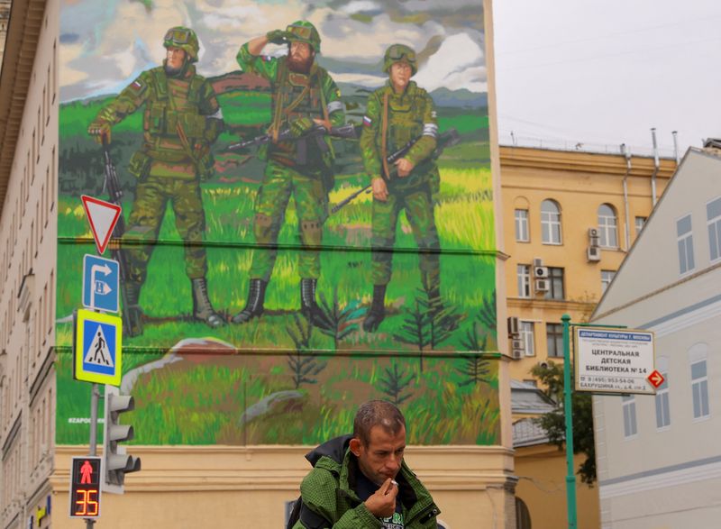 © Reuters. FOTO DE ARCHIVO. Un hombre fuma mientras pasa frente a un mural en Moscú, Rusia, 21 de septiembre del 2022. REUTERS/Evgenia Novozhenina