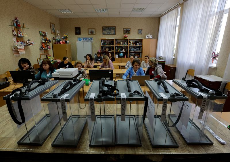 &copy; Reuters. Des membres de la commission électorale locale se rassemblent dans un bureau de vote avant le référendum prévu sur le rattachement de la république populaire autoproclamée de Donetsk à la Russie, à Donetsk, en Ukraine. /Photo prise le 22 septembre