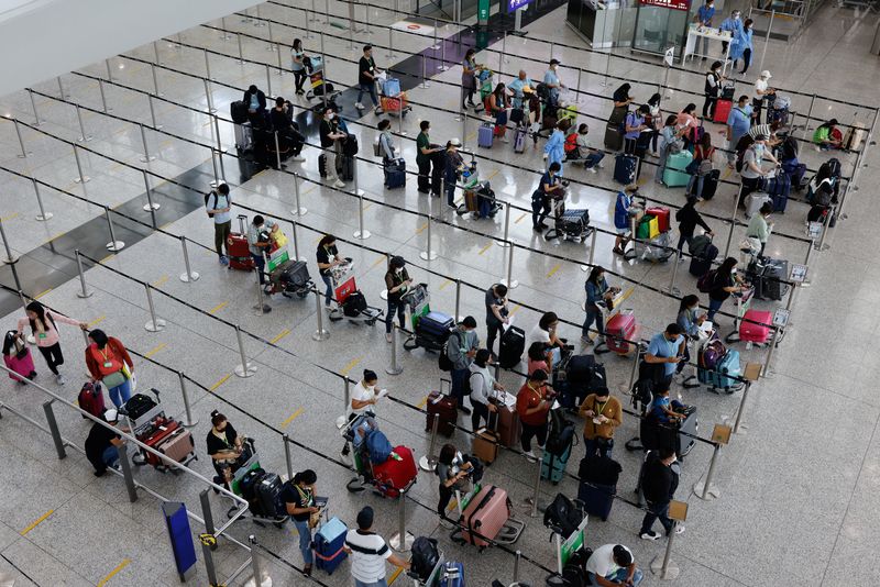 &copy; Reuters. Viaggiatori in coda per raggiungere gli hotel per la quarantena all'aeroporto internazionale di Hong Kong,1 agosto 2022. REUTERS/Tyrone Siu