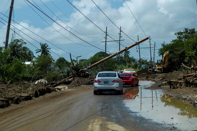 &copy; Reuters. FILE PHOTO: Cars drive under a downed power pole in the aftermath of Hurricane Fiona in Santa Isabel, Puerto Rico September 21, 2022. REUTERS/Ricardo Arduengo/File Photo