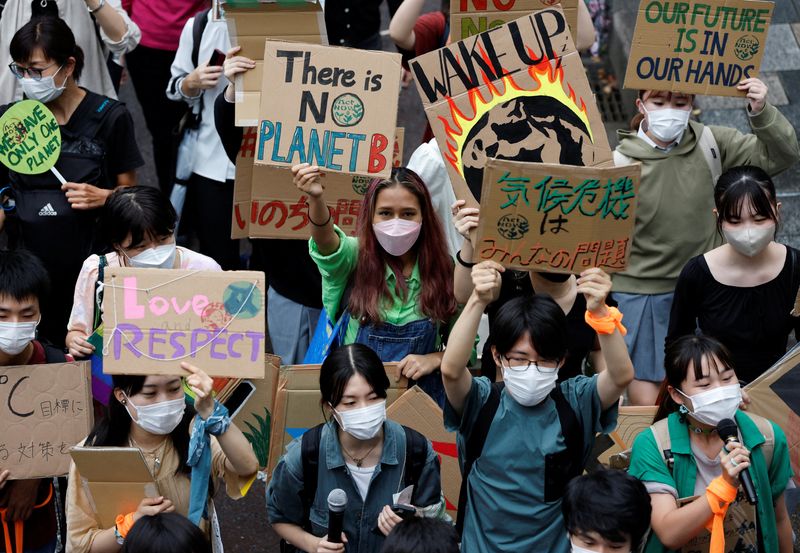 &copy; Reuters. Foto del viernes de un grupo de personas levantando pancartas mientras participan en una marcha de protesta por el clima, en el distrito de Omotesando en Tokio, Japón. 

Sept 23, 2022. REUTERS/Issei Kato