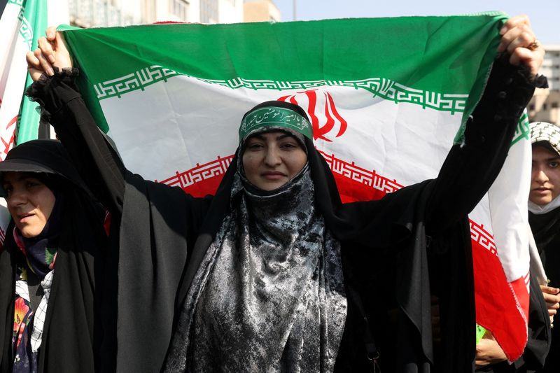 © Reuters. امرأة موالية للحكومة الإيرانية ترفع علم البلاد خلال مسيرة مؤيدة للحكومة في طهران يوم الجمعة. صورة من وكالة غرب اسيا للأنباء. 