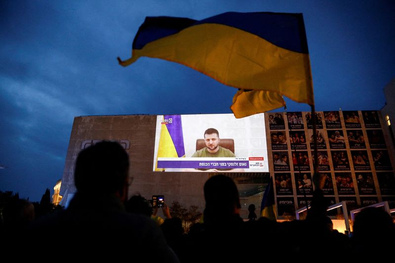 © Reuters. FILE PHOTO: Demonstrators gather in support of Ukraine following Russia's invasion, and watch Zelenskiy's speech as it is broadcasted to the Knesset, Israel's parliament, and projected at Habima Square in Tel Aviv, Israel, March 20, 2022. REUTERS/Corinna Kern/File Photo
