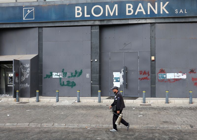 © Reuters. FILE PHOTO: A man walks past a closed Blom Bank branch in Sidon, on the first day of a three-day closure over security concerns, in Sidon, southern Lebanon September 19, 2022. REUTERS/Aziz taher
