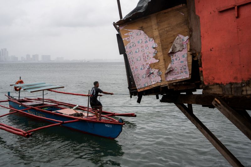 © Reuters. A man prepares to dock his boat, in preparation for Super Typhoon Noru, in Manila, Philippines, September 25, 2022. REUTERS/Lisa Marie David