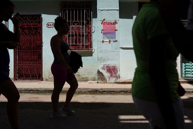 &copy; Reuters. أشخاص يمرون أمام لافتة تشير إلى استفتاء على "قانون الأسرة" الجديد في هافانا عاصمة كوبا يوم الأحد. تصوير: ألكسندر مينيجيني - رويترز.