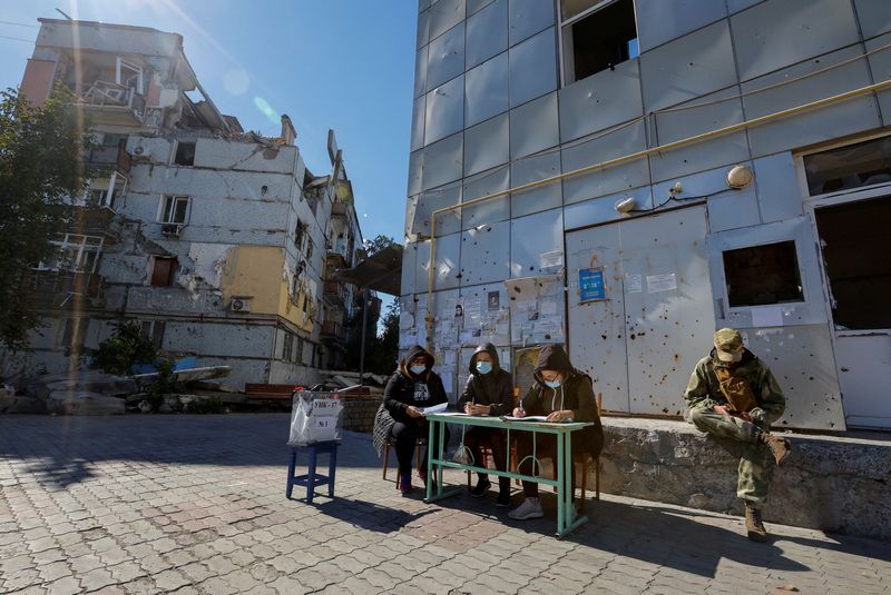 © Reuters. Members of an electoral commission wait for voters near a destroyed residential building on the third day of a referendum on the joining of the self-proclaimed Donetsk People's Republic (DPR) to Russia, in Mariupol, Ukraine September 25, 2022. REUTERS/Alexander Ermochenko   