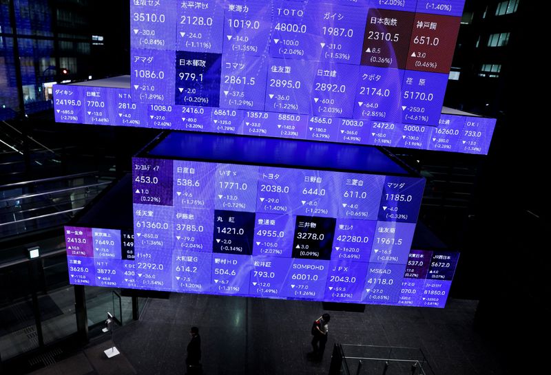 &copy; Reuters. زوار يسيرون بجوار لوحة تظهر حركة تداول الأسهم على مؤشر نيكي القياسي داخل قاعة مؤتمرات بالعاصمة اليابانية طوكيو في 14 سبتمبر أيلول 2022. تصوير : 