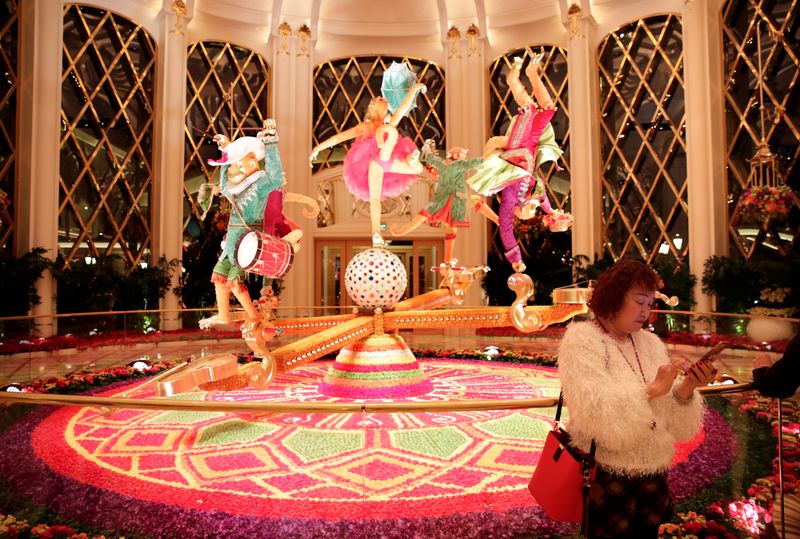 © Reuters. FILE PHOTO: A woman rest next to the decoration inside the Wynn Palace casino resort in Macau, China December 20, 2019, on the 20th anniversary of the former Portuguese colony's return to China. REUTERS/Jason Lee