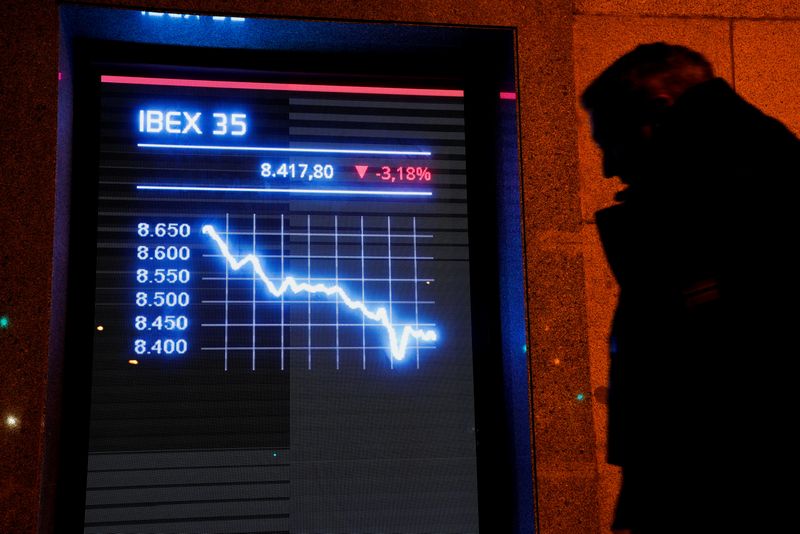&copy; Reuters. FOTO DE ARCHIVO. Un hombre pasa por delante de un cartel electrónico que muestra el índice bursátil español IBEX 35 en Madrid, España. 25 de enero de 2022. REUTERS/Vincent West