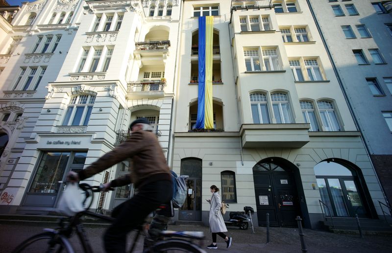 &copy; Reuters. FILE PHOTO: Pedestrians walk past a Ukrainian flag hanging in support of the country on an apartment building at Friedrichshain-Kreuzberg district, amid Russia's invasion of Ukraine, in Berlin, Germany March 24, 2022.     REUTERS/Fabrizio Bensch/File Phot