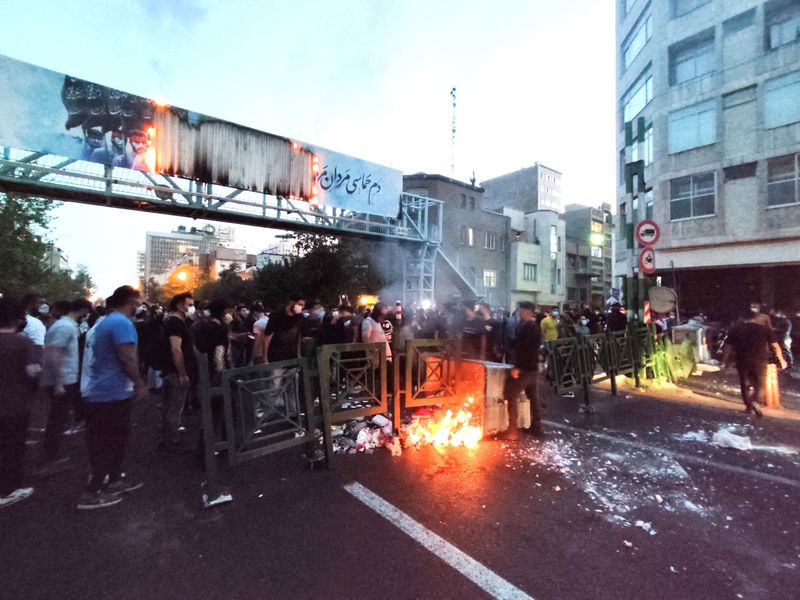© Reuters. أفراد يشعلون النيران خلال احتجاج على وفاة الشابة مهسا أميني في طهران يوم 21 سبتمبر أيلول 2022. صورة لرويترز من وكالة أنباء غرب آسيا.