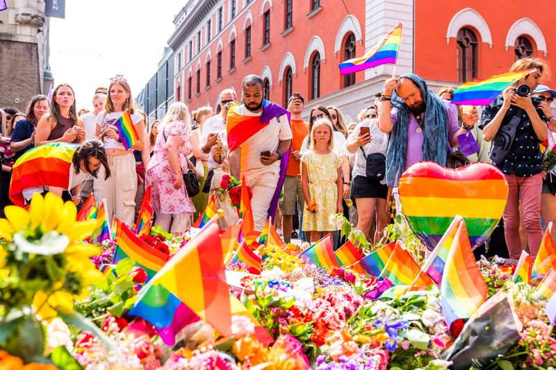 &copy; Reuters. FILE PHOTO: People bring flowers and rainbow flags to pay tribute to the victims as they take part in a spontaneous Pride parade, following a shooting at the London Pub, a popular gay bar and nightclub, after the official event was cancelled, in Oslo, Nor