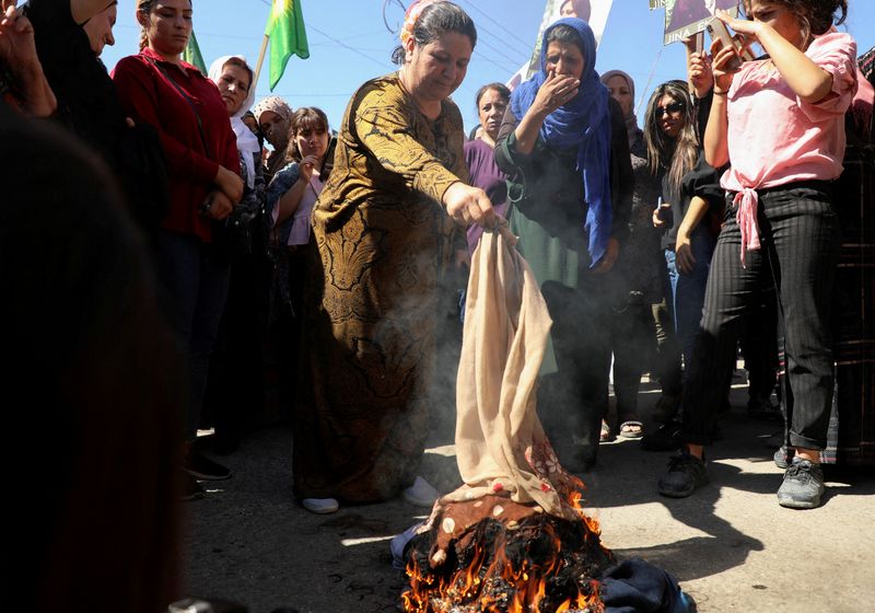 &copy; Reuters. Women burn headscarves during a protest over the death of 22-year-old Kurdish woman Mahsa Amini in Iran, in the Kurdish-controlled city of Qamishli, northeastern Syria September 26, 2022.  REUTERS/Orhan Qereman    