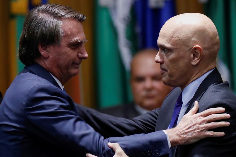 &copy; Reuters. Presidente Jair Bolsonaro e ministro Alexandre de Moraes, do STF, se cumprimentam durante cerimônia em Brasília
19/05/2022 REUTERS/Adriano Machado