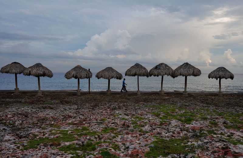 © Reuters. A man collects empty cans at the seafront ahead of the arrival of Tropical Storm Ian in Havana, Cuba, September 26, 2022. REUTERS/Alexandre Meneghini