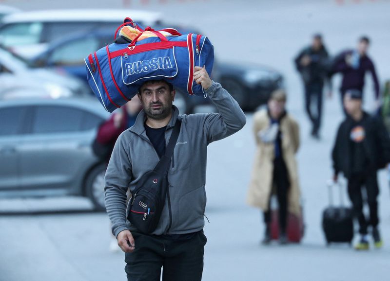 &copy; Reuters. Um homem leva sua mala na cabeça em meio a viajantes na fronteira da Rússia com a Geórgia. REUTERS/Irakli Gedenidze