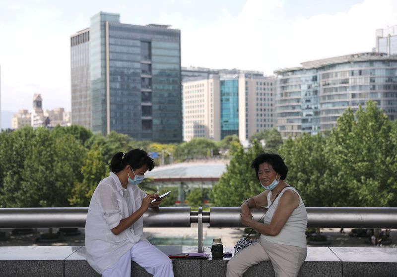 &copy; Reuters. سيدتان صينيتان تستريحان قريبا من إحدى الساحات في العاصمة الصينية بكين في صورة من أرشيف رويترز 