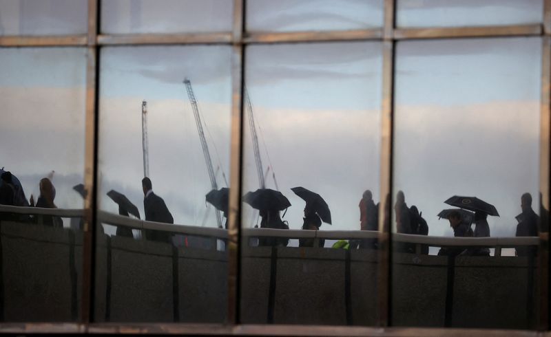 &copy; Reuters. Commuters, reflected in windows of an office, walk across London Bridge toward the financial district, in London, Britain, September 26, 2022.  REUTERS/Peter Nicholls