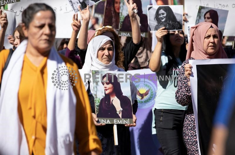 &copy; Reuters. Mujeres portan fotos durante una protesta por la muerte de la mujer kurda de 22 años Mahsa Amini en Irán, en la ciudad de Qamishli, controlada por los kurdos, en el noreste de Siria. 26 de septiembre de 2022.  REUTERS/Orhan Qereman. NO DISPONIBLE PARA R