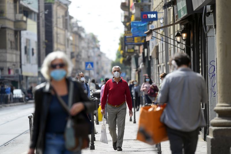 &copy; Reuters. People wearing protective masks walk in an increasingly busy street, amid the coronavirus disease (COVID-19) outbreak, in Milan, Italy April 18, 2020. REUTERS/Daniele Mascolo