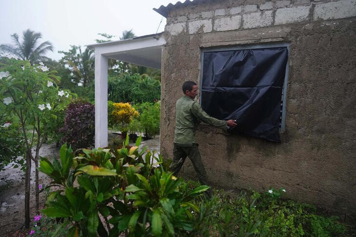 &copy; Reuters. El granjero Cito Braga protege una ventana de su casa antes de la llegada del huracán Ian a Coloma, Cuba. 26 septiembre 2022. REUTERS/Alexandre Meneghini