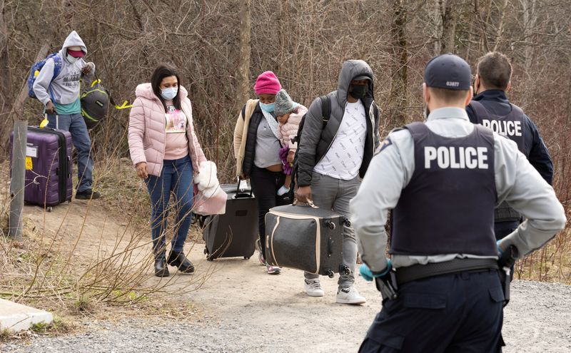 &copy; Reuters. FILE PHOTO: Asylum seekers cross into Canada from the U.S. border near a checkpoint on Roxham Road near Hemmingford, Quebec, Canada April 24, 2022. REUTERS/Christinne Muschi/File Photo