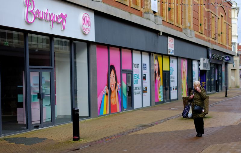 &copy; Reuters. A woman walks past a row of empty retail units on an empty shopping street in Blackpool, Britain, March 9, 2021. REUTERS/Phil Noble