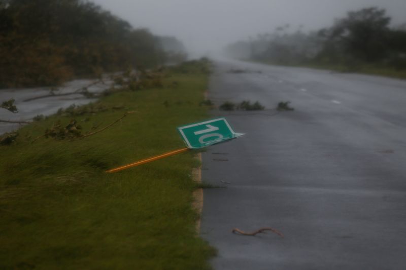 &copy; Reuters. 　９月２７日、米フロリダ州に向けて北上中のハリケーン「イアン」の影響で、米南部メキシコ湾の石油生産が約１１％が停止した。写真は「イアン」の被害で倒れた道路標識。キューバで