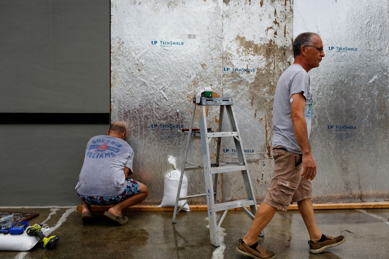 &copy; Reuters. Men work boarding up a shop window as Hurricane Ian spins toward the state carrying high winds, torrential rains and a powerful storm surge, in Port Charlotte, Florida, U.S. September 27, 2022. REUTERS/Marco Bello