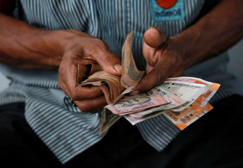 &copy; Reuters. FILE PHOTO: An attendant at a fuel station arranges Indian rupee notes in Kolkata, India, August 16, 2018. REUTERS/Rupak De Chowdhuri/File Photo