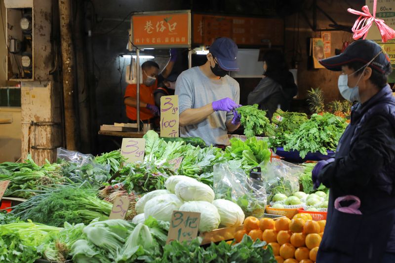 &copy; Reuters. FILE PHOTO: A man wearing a face mask to prevent the spread of the coronavirus disease (COVID-19) works at a stall in a market in Taipei, Taiwan, November 26, 2021. REUTERS/Annabelle Chih/File Photo
