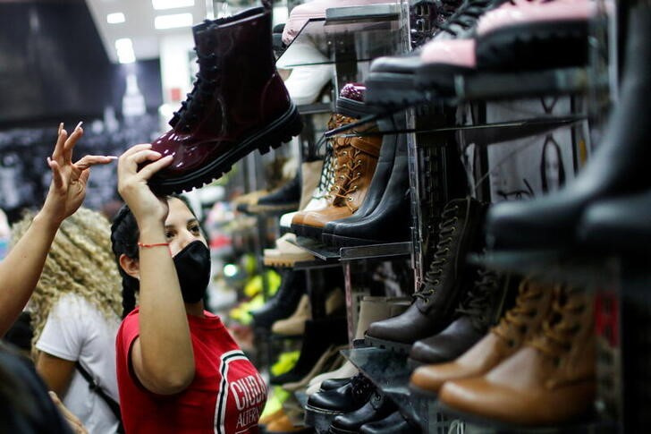 &copy; Reuters. Imagen de archivo de una vendedora mostrando una bota a una compradora en una tienda de un centro comercial de Caracas, Venezuela.