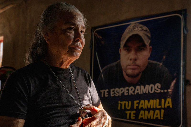 &copy; Reuters. Manki Lugo, 68, stands in front of a portrait of her missing son Juan, in Los Mochis, Sinaloa, Mexico, December 9, 2021. Juan, then 33, disappeared in July 2015, and a month later Lugo joined a local search group 'Las Rastreadoras del Fuerte', or the Trac