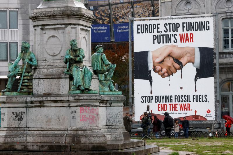 &copy; Reuters. FILE PHOTO: Activists and members of the media stand next to an unveiled billboard reading "Europe, Stop Funding Putin's War" outside the European Parliament in Brussels, Belgium September 27, 2022. REUTERS/Yves Herman/File Photo