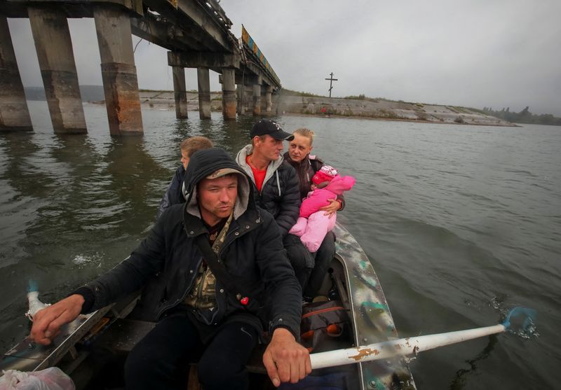 Rowing past their severed road bridge, Ukrainians return to liberated villages