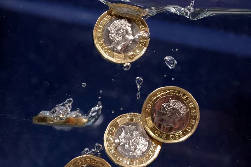 © Reuters. Pound coins plunge into water in this illustration taken, May 23, 2022. REUTERS/Dado Ruvic/Illustration
