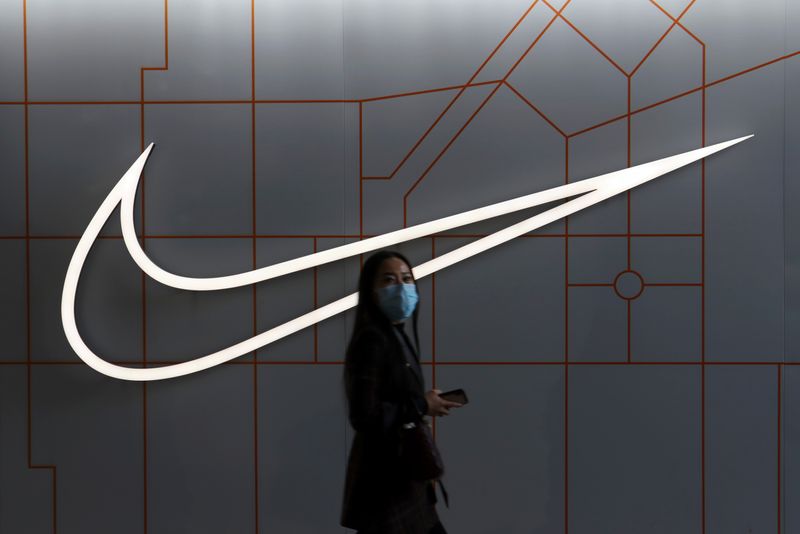 &copy; Reuters. FILE PHOTO: A woman walks past a store of the sporting goods retailer Nike Inc at a shopping complex in Beijing, China March 25, 2021. REUTERS/Florence Lo/File Photo