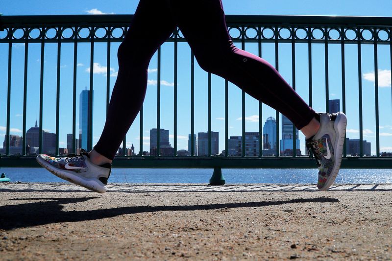© Reuters. FILE PHOTO: A jogger wearing Nike shoes runs past the Boston skyline along the Charles River in Cambridge, Massachusetts, U.S., March 18, 2019.   REUTERS/Brian Snyder
