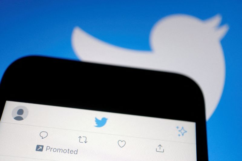 © Reuters. FILE PHOTO: A promoted tweet on Twitter app is displayed on a mobile phone near a Twitter logo, in this illustration picture taken Sept. 8, 2022. REUTERS/Florence Lo/Illustration/File Photo/File Photo