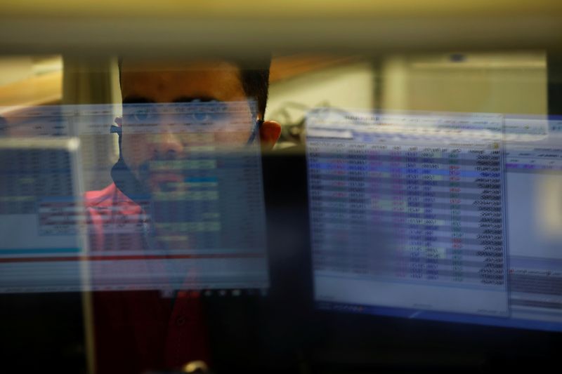 © Reuters. A computer screen is reflected in the glass window of a booth where a broker is monitoring the market in the halls of the Pakistan Stock Exchange, a day after an attack in Karachi, Pakistan June 30, 2020. REUTERS/Akhtar Soomro/Files
