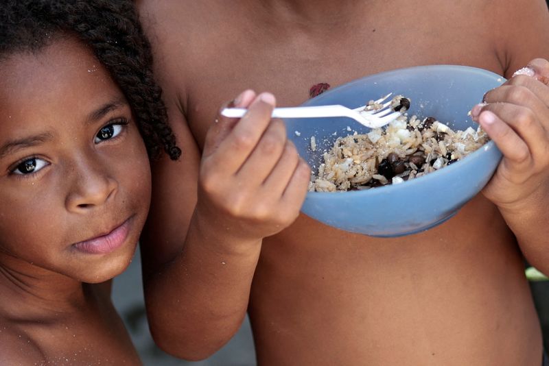 &copy; Reuters. Thawanny Silva de Souza, de 6 anos, (E) e Rafael Silva de Souza, de 9 anos, (D), comem prato com arroz, feijão e ovo na Favela do Arci-Íris, em Recife 
15/09/2022 REUTERS/Ueslei Marcelino