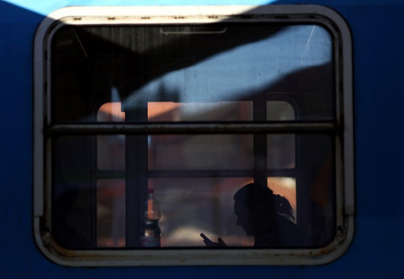 © Reuters. A Ukrainian refugee onboard a train to Warsaw, uses a mobile phone inside a carriage before departing Przemysl Glowny train station in  Poland, March 23, 2022.   REUTERS/Hannah McKay 