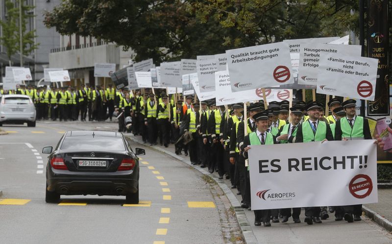 © Reuters. Members of AEROPERS - Airline Pilots Association carry posters on their march to protest in front of the headquarters of Swiss International Air Lines in Kloten, Switzerland September 29,  2022.  REUTERS/Arnd Wiegmann