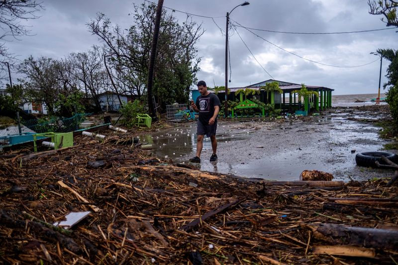 &copy; Reuters. FOTO DE ARCHIVO: Un hombre camina entre escombros después del paso del huracán Fiona en Guayanilla, Puerto Rico, 19 de septiembre de 2022. REUTERS/Ricardo Arduengo